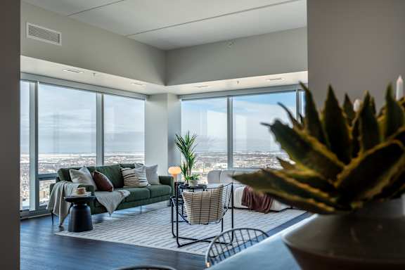 A living room with a couch, a table, and a view of the city.