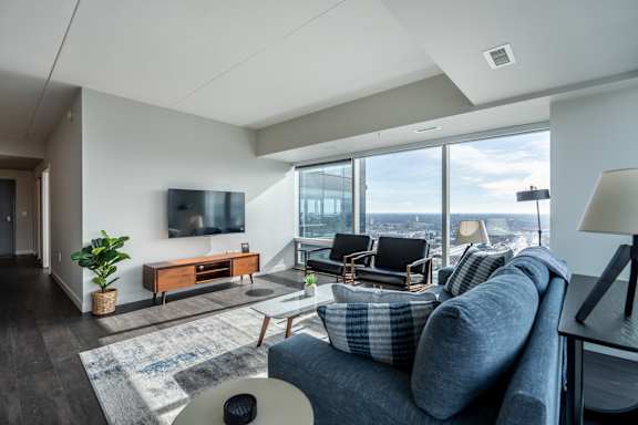 A living room with a grey couch and a wooden cabinet.