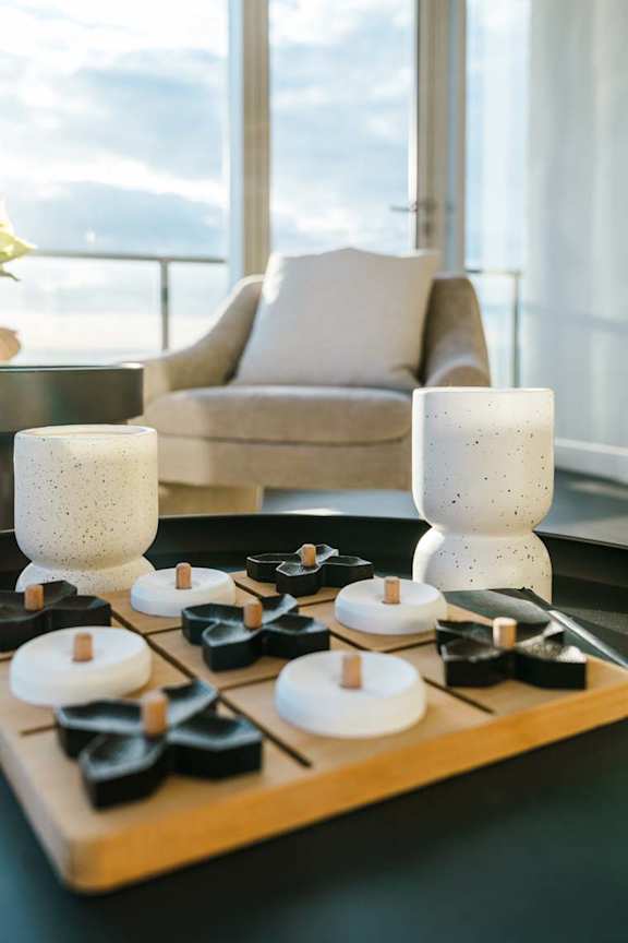 Candles of different sizes and shapes are arranged on a wooden board.