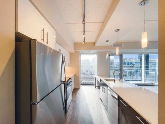 a kitchen with white countertops and stainless steel appliances