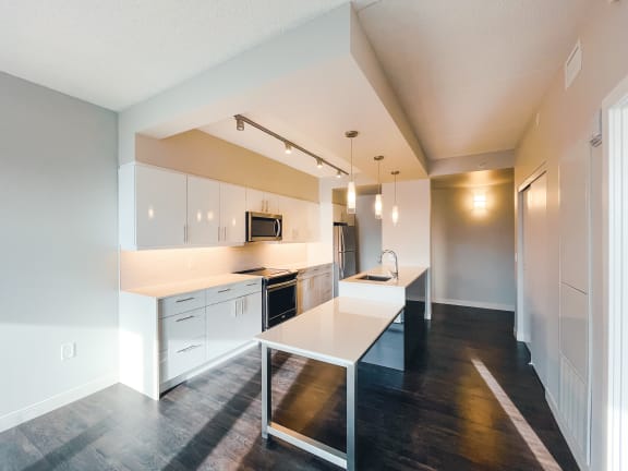 a kitchen with white cabinets and a white island