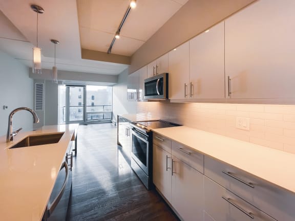a kitchen with white cabinets and stainless steel appliances