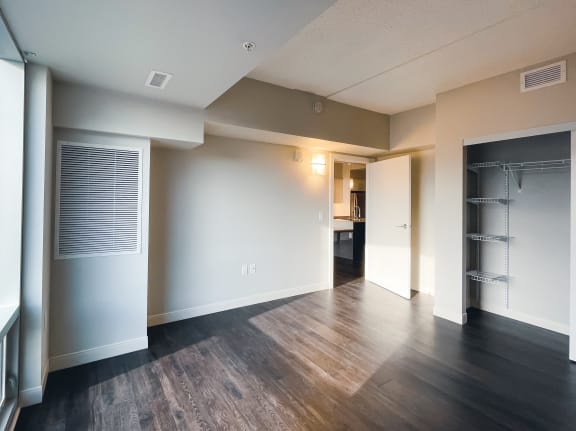 a bedroom with a medium hardwood floor and white walls