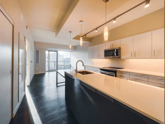 a kitchen with white cabinets and black countertops