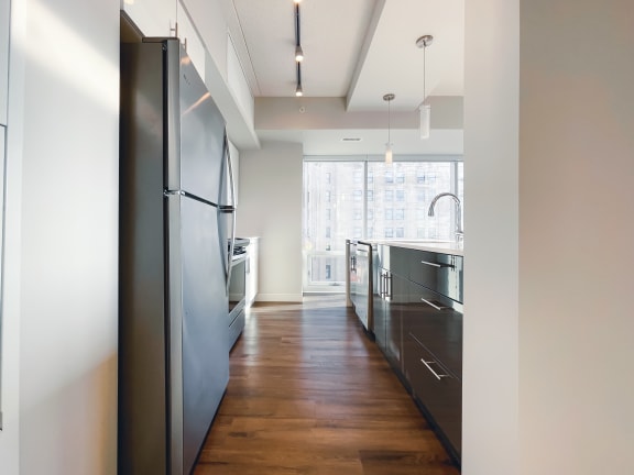 a kitchen with black cabinets and a wooden floor