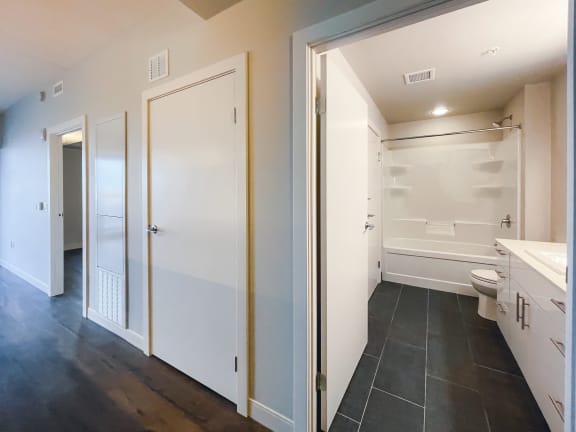 a bathroom with a white toilet next to a white sink and a white bathtub