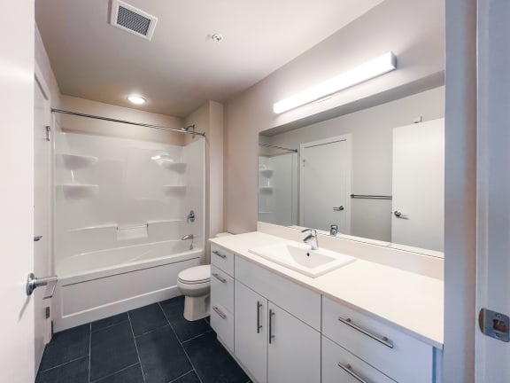a bathroom with white cabinets and a white toilet
