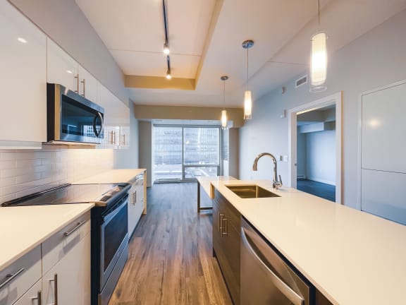 a kitchen with white countertops and stainless steel appliances