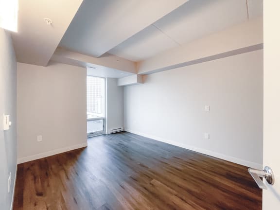 a bedroom with hardwood floors and grey walls