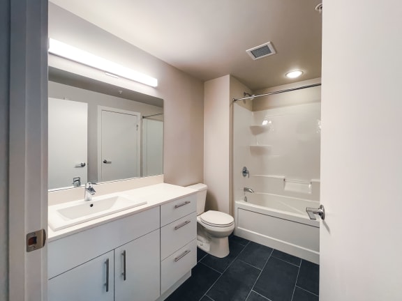 a bathroom with a white sink and toilet next to a white bathtub