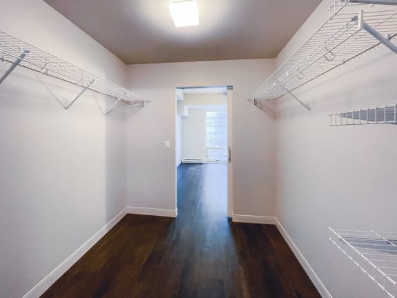a bedroom with white walls and hardwood floors