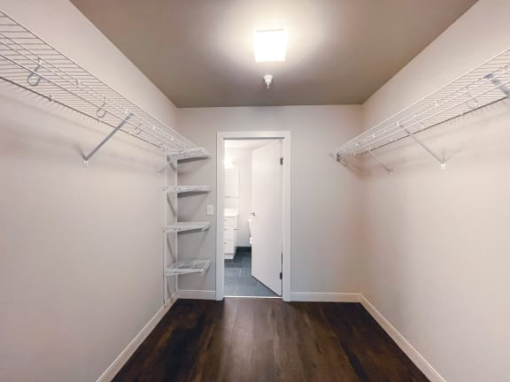 a bedroom with white walls and a wooden floor