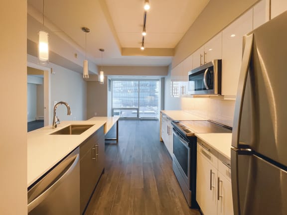 a kitchen with white countertops and stainless steel appliances