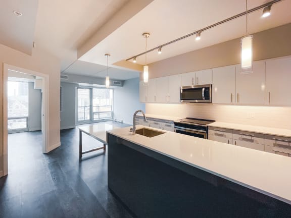 a kitchen with white cabinets and black countertops