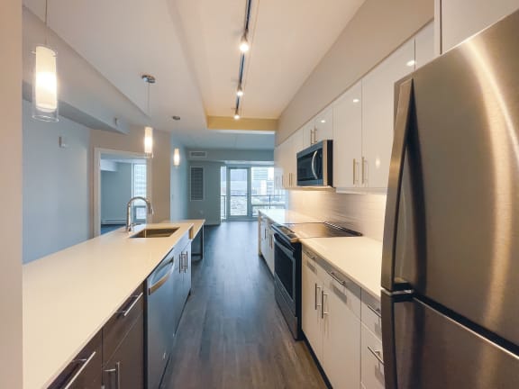 a kitchen with white countertops and stainless steel appliances
