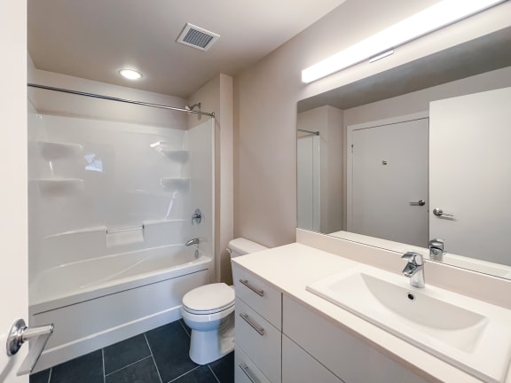 a bathroom with a white sink and toilet next to a white bathtub