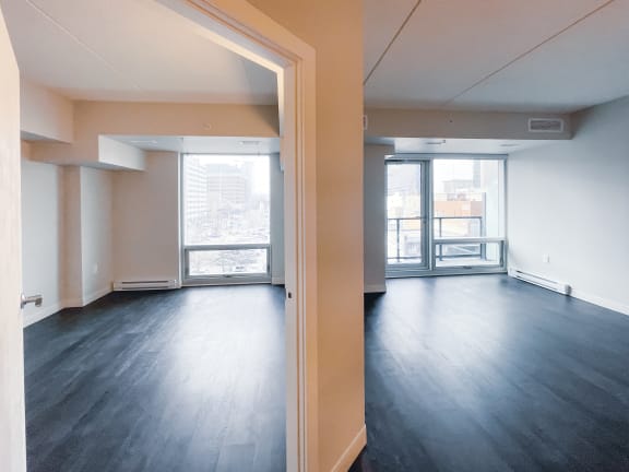 an empty living room with hardwood floors and a balcony