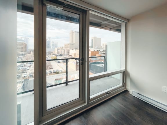 a bedroom with a large window and a balcony