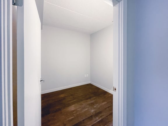 a small room with a hardwood floor and white walls
