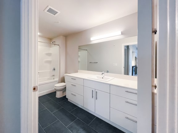 a bathroom with white cabinets and a white toilet