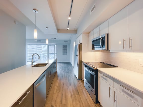 a kitchen with white countertops and stainless steel appliances