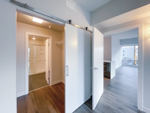 a bedroom with a medium hardwood floor and a closet with a sliding door