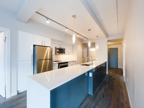a kitchen with white cabinets and stainless steel appliances