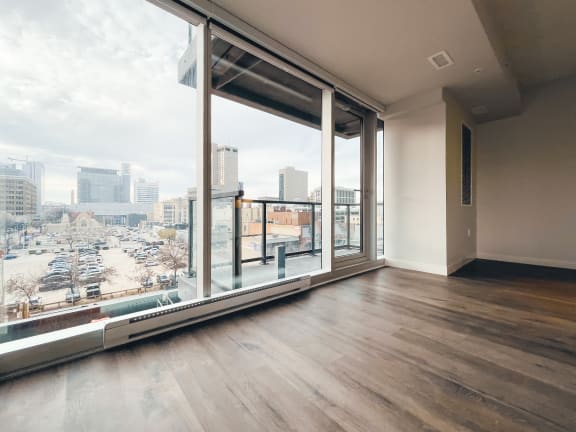 an empty living room with a large window and a view of the city