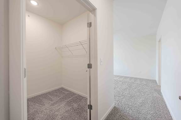 A white room with a grey carpet and a white door.