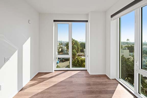 A room with a view of the city through large windows.