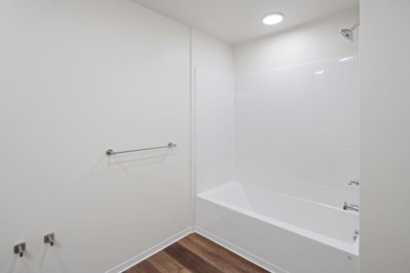 A white bathroom with a tub and a shower.