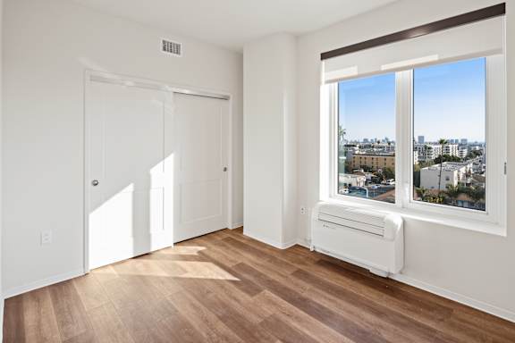 A room with a window overlooking a cityscape.