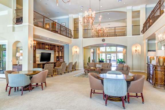 Large, well-furnished living room with balcony at The Laurel at Vintage Park 55+ Apartments, Tomball, TX