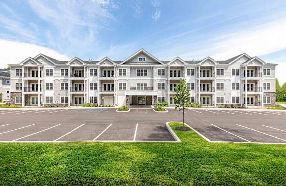 A large white building with a parking lot in front.