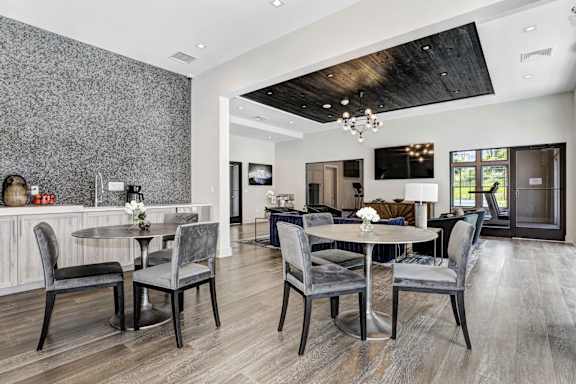 A modern dining room with a wooden table and chairs.
