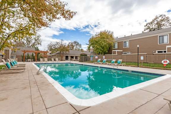 A large outdoor swimming pool surrounded by lounge chairs.