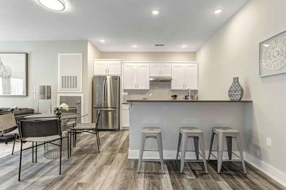 A kitchen with a bar area and a dining table.