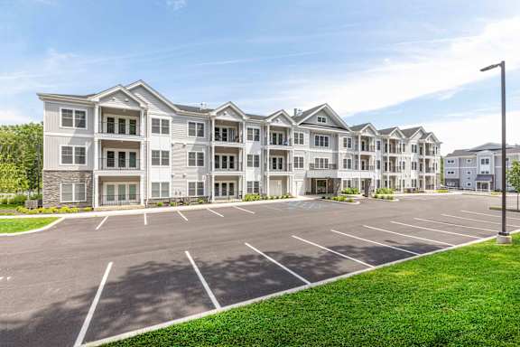 A large apartment complex with a parking lot in front.