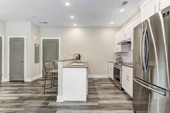 A modern kitchen with a white island and stainless steel appliances.