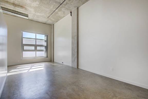 A large empty room with a window on the left side at RiDE at RiNo Apartments, Colorado, 80216
