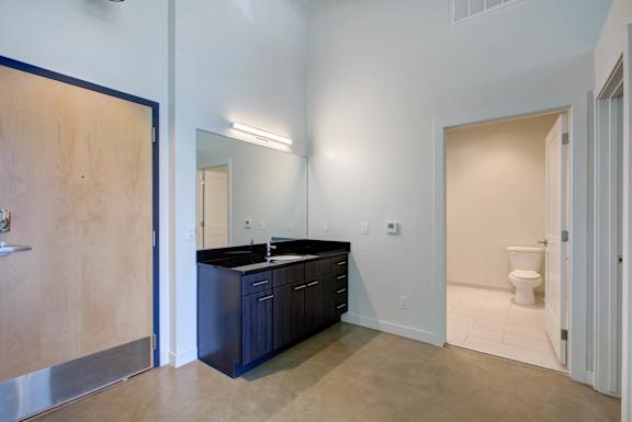 A bathroom with a sink, toilet, and mirror at RiDE at RiNo Apartments, Colorado
