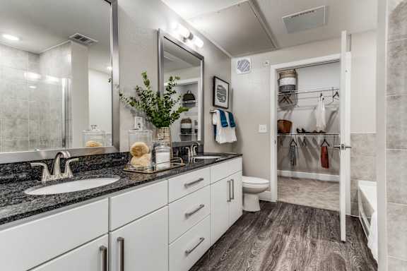 A bathroom with a sink, mirror, and towel rack.