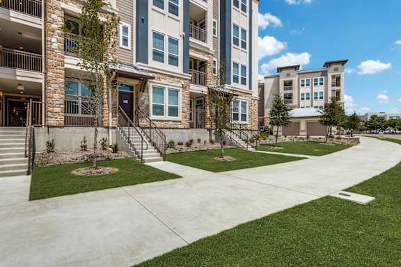 Apartment complex with a grassy area in front.
