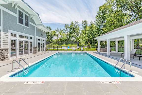 A large outdoor swimming pool with a building in the background.