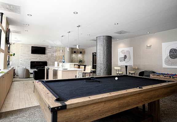 Recreation room with pool table and lounge seating at 222 Saratoga Apartments, Baltimore, MD