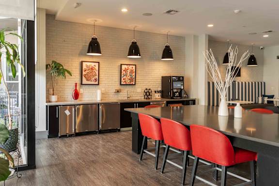 A modern kitchen with red chairs and a wooden floor at Regatta Sloans Lake Apartments, Denver, CO, 80204