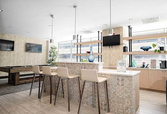 Community dining area with bar seating and kitchenette at 222 Saratoga Apartments, Baltimore, 21202