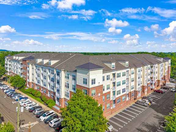 A large apartment complex with a parking lot in front.