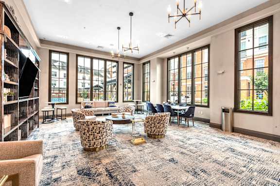 A large room with a carpeted floor and a long table with chairs.