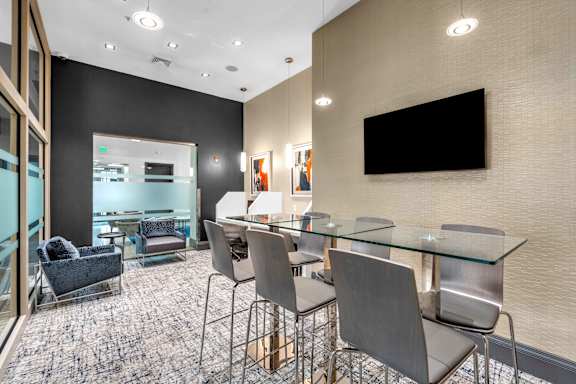 A conference room with a glass table and chairs.